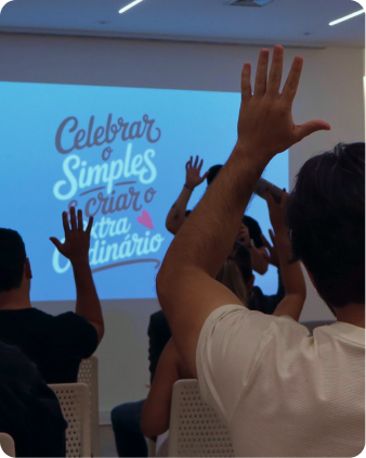 Participantes com as mãos levantadas durante atividade